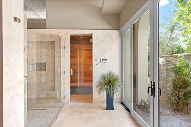 bathroom with a shower with door and french doors