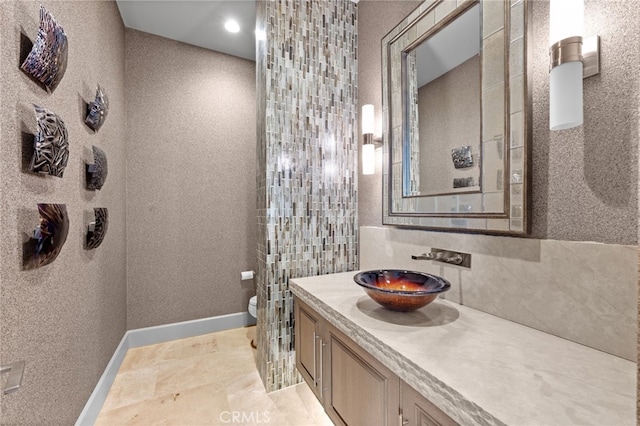 bathroom with tasteful backsplash, vanity, and toilet