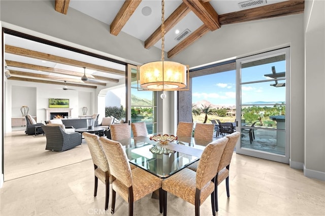 dining area with a mountain view and lofted ceiling with beams