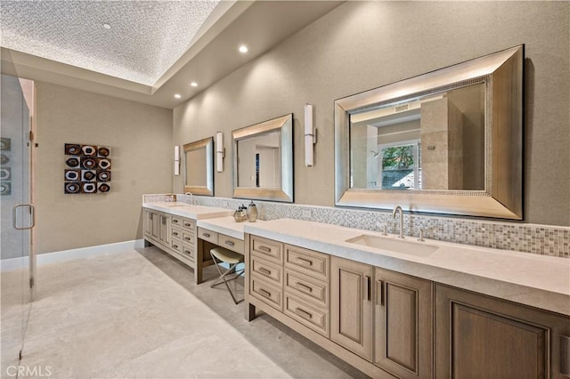 bathroom with vanity, tasteful backsplash, and a shower with door