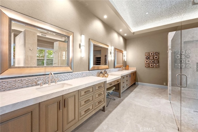 bathroom featuring tasteful backsplash, vanity, and an enclosed shower