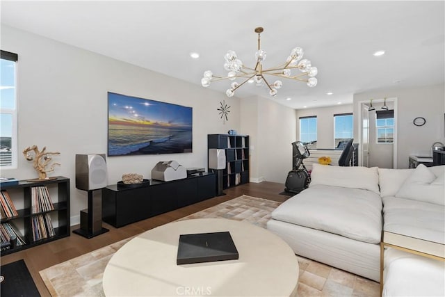 living area with a chandelier, recessed lighting, baseboards, and wood finished floors