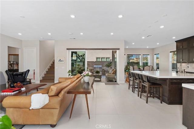 living room featuring sink and light tile patterned floors