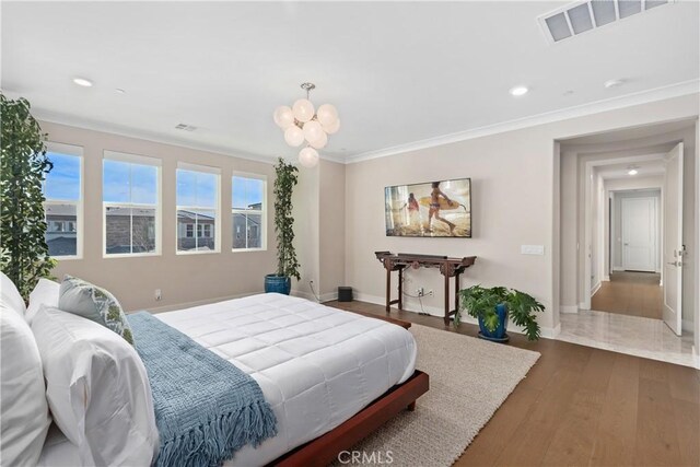 bedroom featuring an inviting chandelier, ornamental molding, and dark hardwood / wood-style flooring