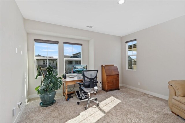 office space featuring plenty of natural light and light colored carpet