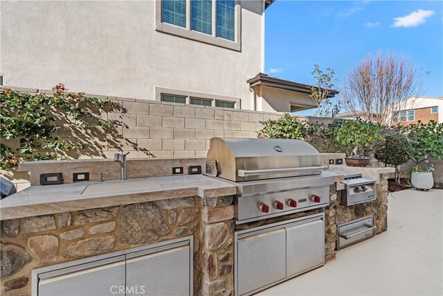 view of patio featuring area for grilling and sink