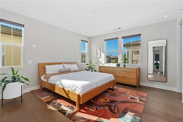 bedroom with dark hardwood / wood-style floors