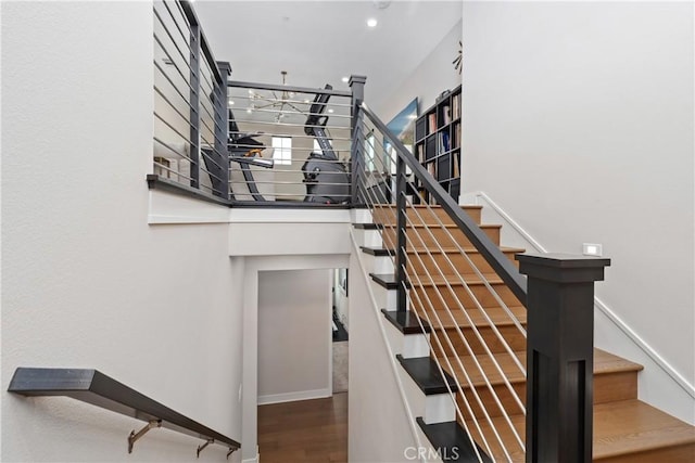 staircase with a high ceiling and wood finished floors