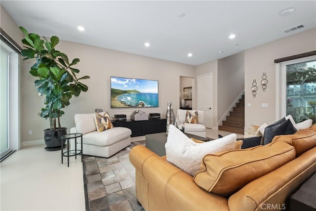 living area with visible vents, stone finish floor, recessed lighting, baseboards, and stairs