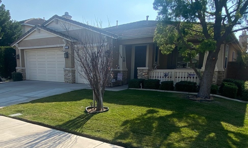 craftsman inspired home with a garage and a front yard