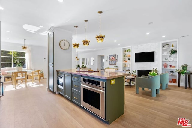 kitchen with a fireplace, oven, pendant lighting, light hardwood / wood-style flooring, and built in shelves