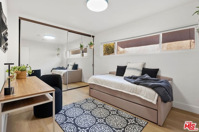 bedroom featuring light wood-type flooring and a closet