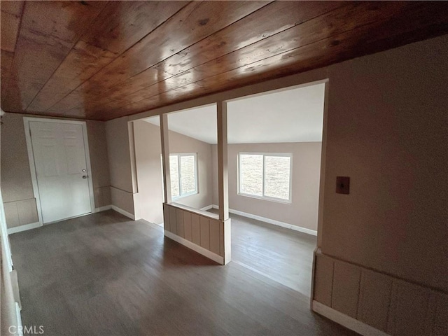 empty room featuring dark wood-type flooring, lofted ceiling, and wooden ceiling