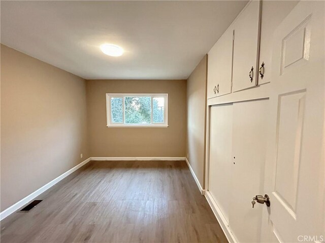 unfurnished bedroom with a closet and light wood-type flooring