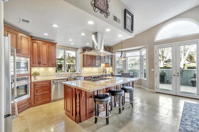 kitchen featuring sink, backsplash, island exhaust hood, a center island, and stainless steel appliances