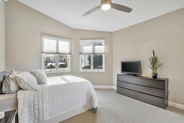 bedroom with ceiling fan, light colored carpet, and vaulted ceiling