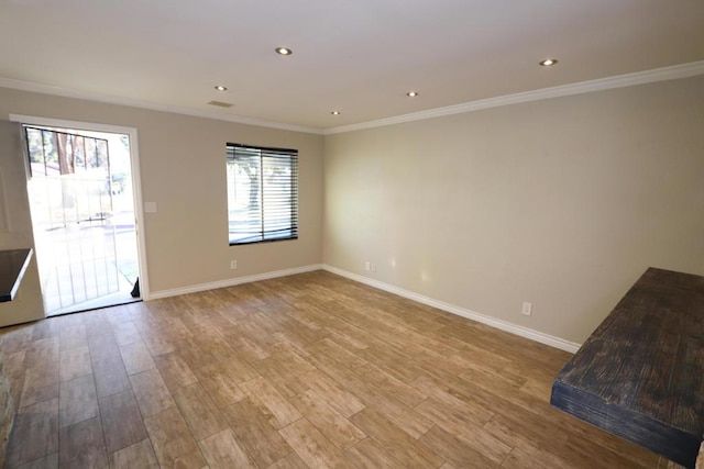 unfurnished living room featuring ornamental molding and light hardwood / wood-style flooring