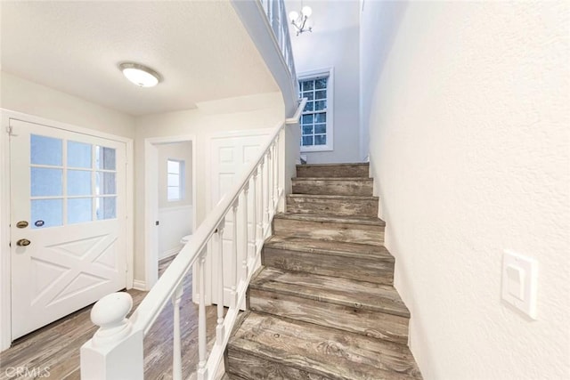 stairs with a textured ceiling and hardwood / wood-style flooring