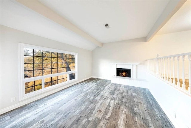 unfurnished living room with wood-type flooring and lofted ceiling with beams