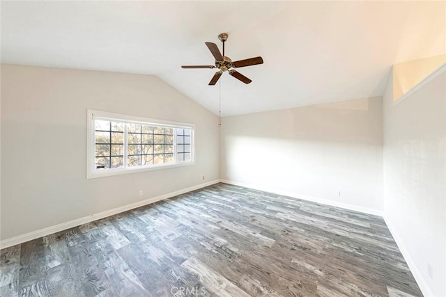 spare room featuring ceiling fan, dark wood-type flooring, and vaulted ceiling