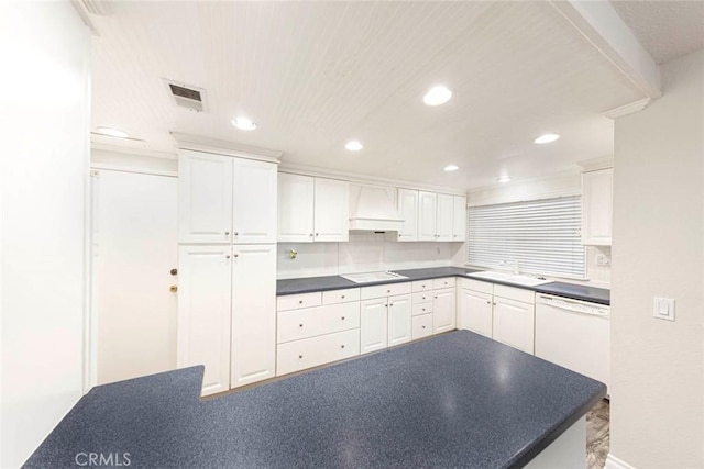 kitchen with custom exhaust hood, white dishwasher, white cabinetry, and electric cooktop