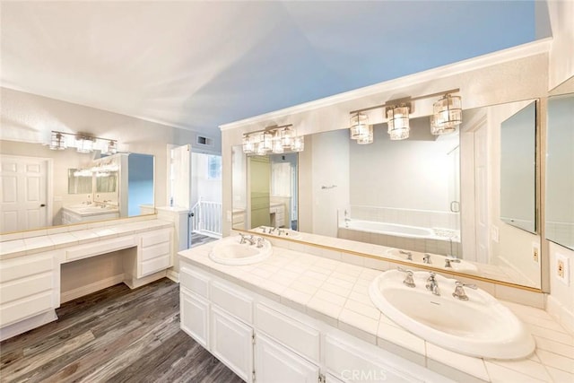 bathroom featuring hardwood / wood-style flooring, vanity, and a washtub