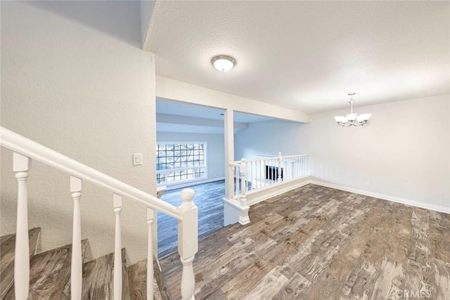 interior space with hardwood / wood-style floors, a textured ceiling, and a chandelier