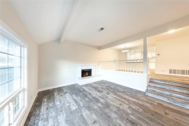 unfurnished living room with dark wood-type flooring, lofted ceiling with beams, and a notable chandelier