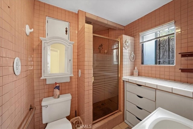 bathroom with toilet, tile walls, walk in shower, and vanity