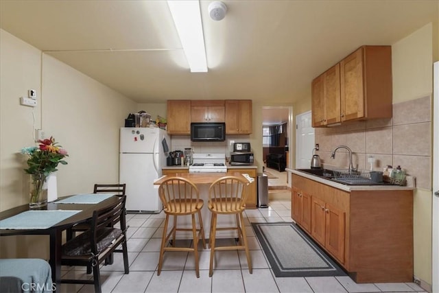 kitchen with a kitchen island, white fridge, decorative backsplash, sink, and light tile patterned floors