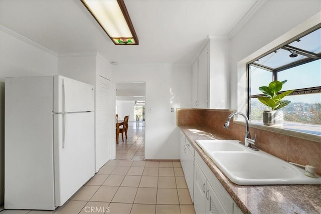 kitchen featuring light tile patterned flooring, white refrigerator, white cabinetry, and sink