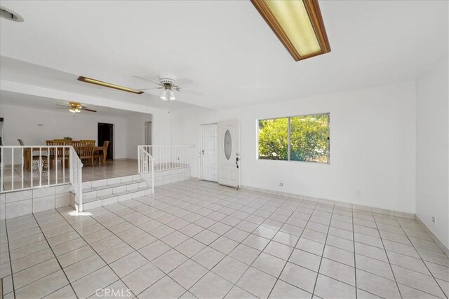 empty room with ceiling fan and light tile patterned floors