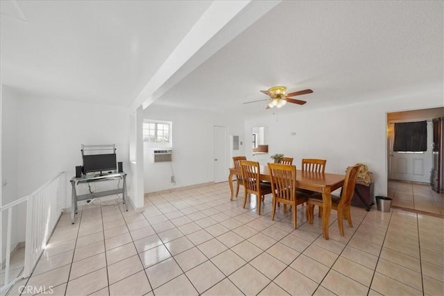 dining area featuring ceiling fan, light tile patterned floors, and beamed ceiling