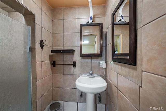 bathroom with tile walls, backsplash, and sink