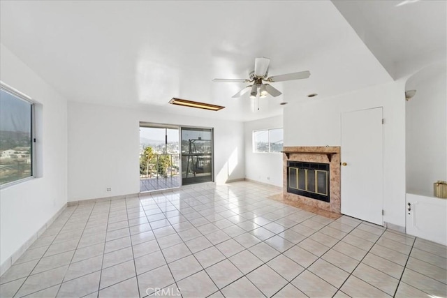 unfurnished living room featuring ceiling fan, light tile patterned floors, and a high end fireplace