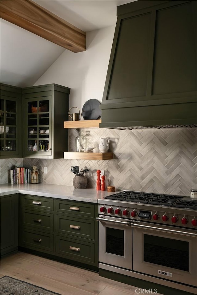 kitchen with green cabinets, beamed ceiling, tasteful backsplash, and range with two ovens