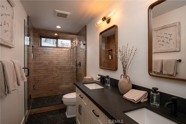 bathroom with toilet, a shower with shower door, and vanity