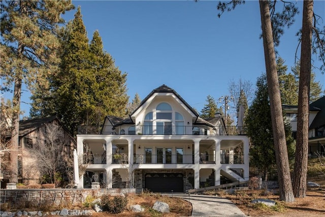 back of property with a garage and a balcony