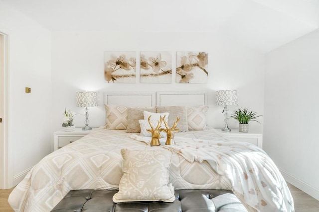 bedroom with hardwood / wood-style flooring and vaulted ceiling