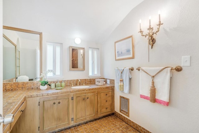 bathroom featuring lofted ceiling and vanity