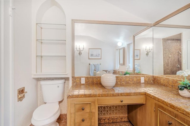 bathroom with lofted ceiling, vanity, and toilet