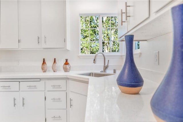 kitchen with white cabinetry, sink, and a healthy amount of sunlight