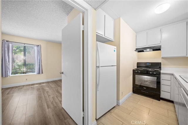 kitchen featuring white fridge, a textured ceiling, black range with gas stovetop, and white cabinets