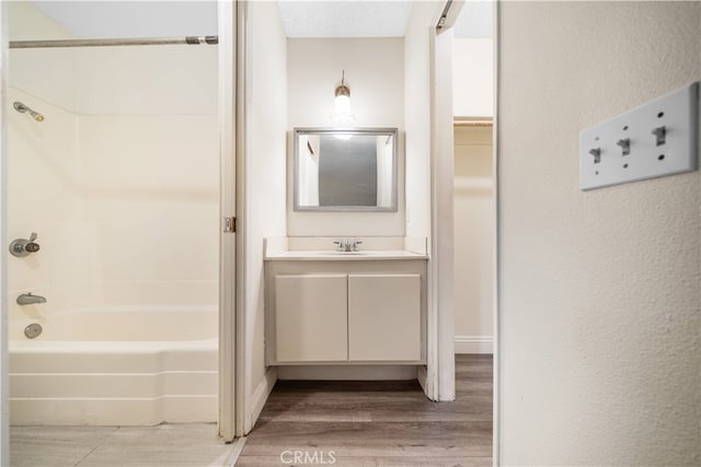 bathroom with  shower combination, wood-type flooring, and vanity