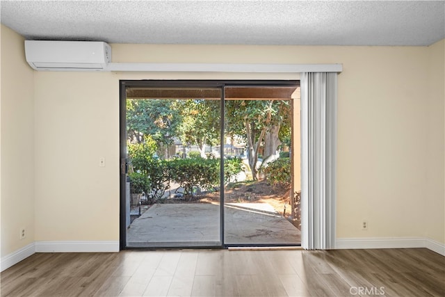 entryway featuring a wall unit AC, a textured ceiling, and hardwood / wood-style floors