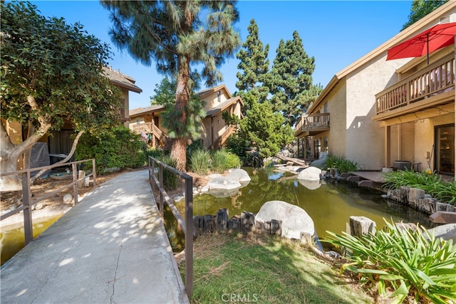 view of community featuring a garden pond