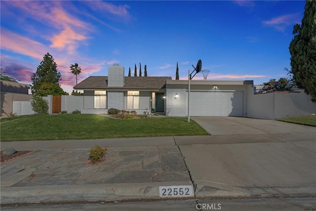 single story home with a garage and a yard