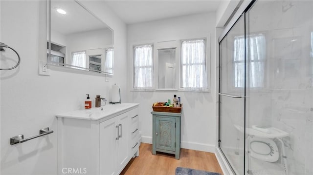 bathroom with vanity, wood-type flooring, and an enclosed shower