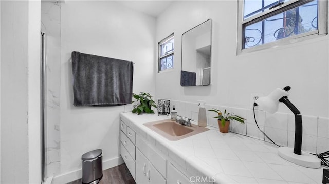 bathroom featuring hardwood / wood-style flooring, vanity, and decorative backsplash