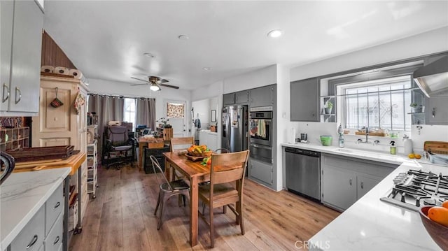 kitchen featuring appliances with stainless steel finishes, sink, gray cabinetry, and light hardwood / wood-style floors